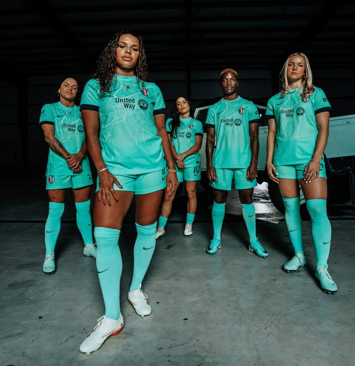 KC Current players show off the club’s new kit for the 2025 NWSL season. The teal jerseys are the first of their kind for a Current uniform, and include a map of the Kansas City area.