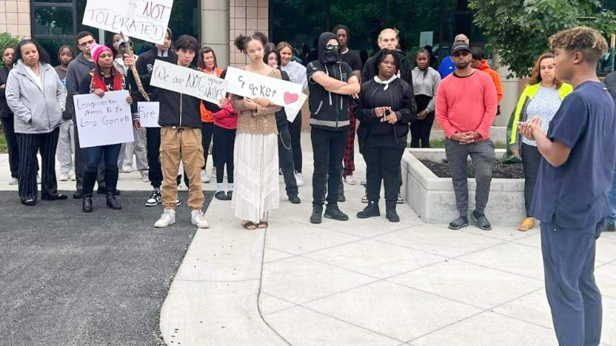 Olathe student David Brox leads protesters in chants May 15 in front of school district headquarters. Students demanded that district officials take stronger steps to combat racism and discipline students for harassment and discrimination.