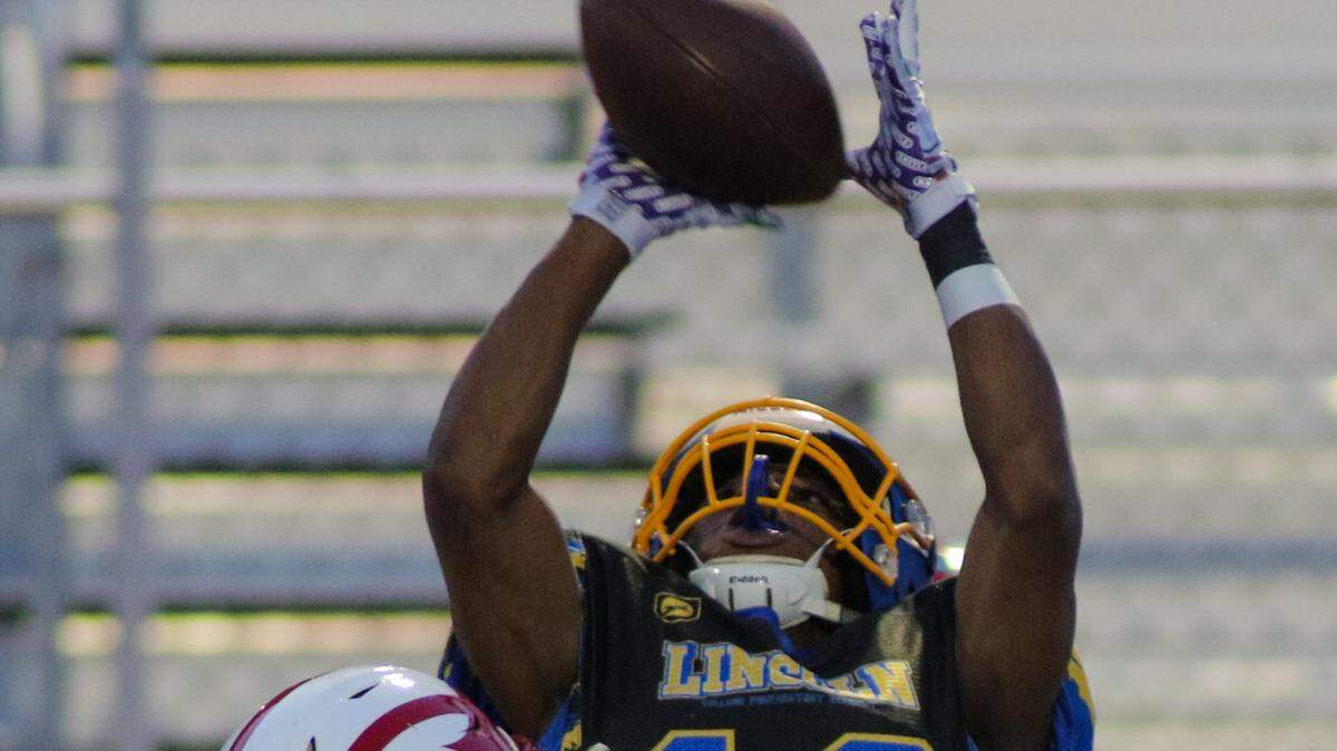 Lincoln Prep wide receiver Darryl Williams goes up for a catch attempt against Pembroke Hill in Friday night’s game at Lincoln Prep. The Blue Tigers took a 14-7 lead into halftime.