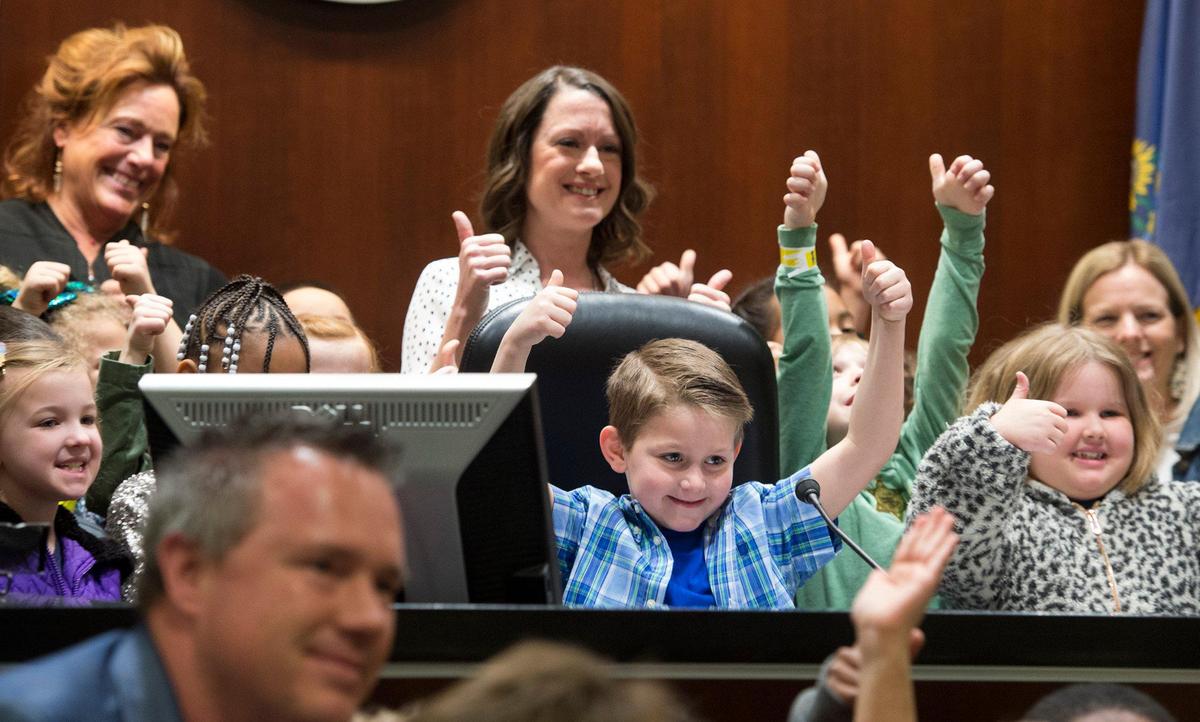 Newly adopted Tyler Jaxson Jones, 6, center, smiled and gave a thumbs-up alongside classmates who came from Havencroft Elementary School to watch his adoption in Johnson County District Court before Judge Kathleen Sloan, left, on Monday in Olathe. Tyler was the sixth child adopted by Laura Jones of Olathe.