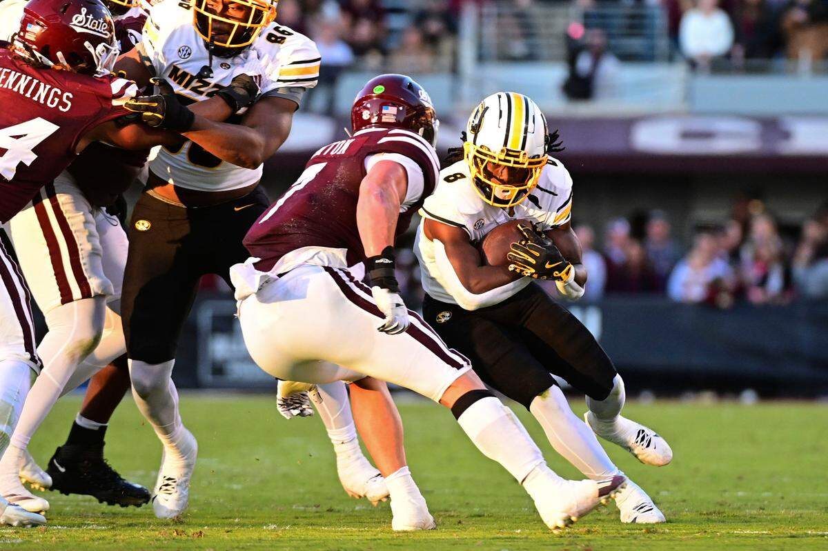 Missouri Tigers running back Nate Noel, right, looks for yardage against the Mississippi State Bulldogs during an SEC college football game at Davis Wade Stadium at Scott Field on Saturday, Nov. 23, 2024 in Starkville, Mississippi.