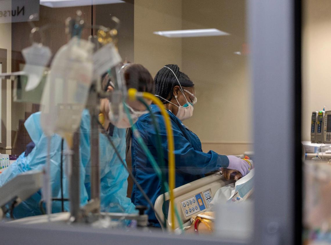 Two registered nurses at Saint Luke’s Hospital of Kansas City care for a COVID patient hooked up to a ventilator and an ECMO bypass machine.