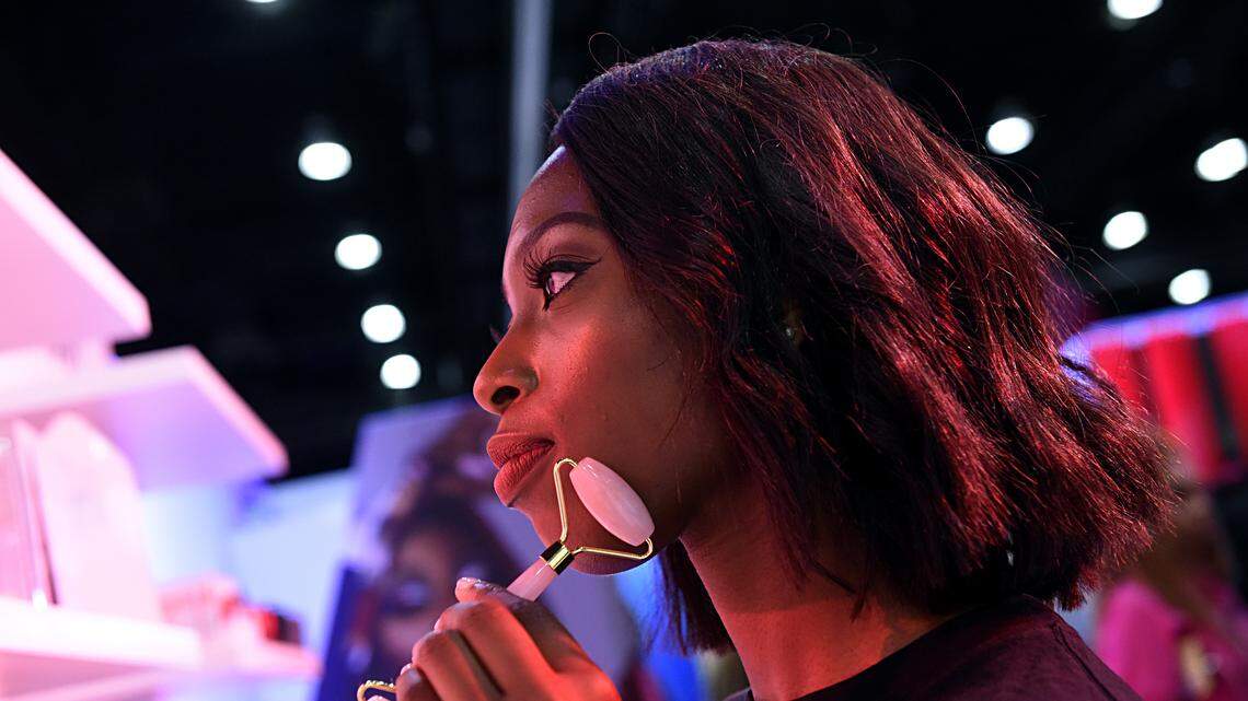 a girl uses a facial tool.