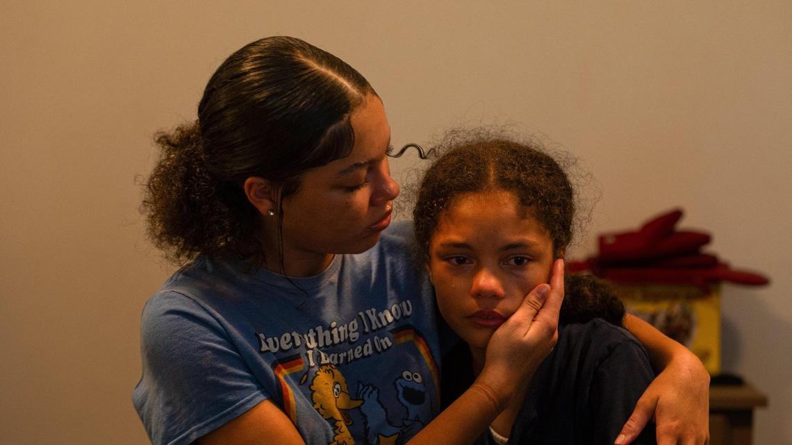 Raegan, right, wipes away her sister Melaina’s tears while her family tells stories about her brother Jaden Brown on Oct. 12, 2023, at their home in Kansas City. Brown was one of the victims of a double homicide that occurred on Oct. 1, 2023, in Raytown.