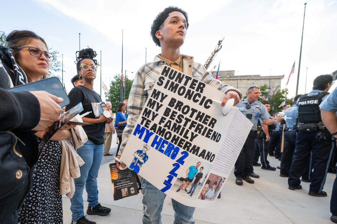 Marcos Moreno of Kansas City holds a sign for his friend, slain KCKPD officer Hunter Simoncic, at a candlelight vigil in his honor, on Thursday, Aug. 28, 2025, in Kansas City, Kansas.