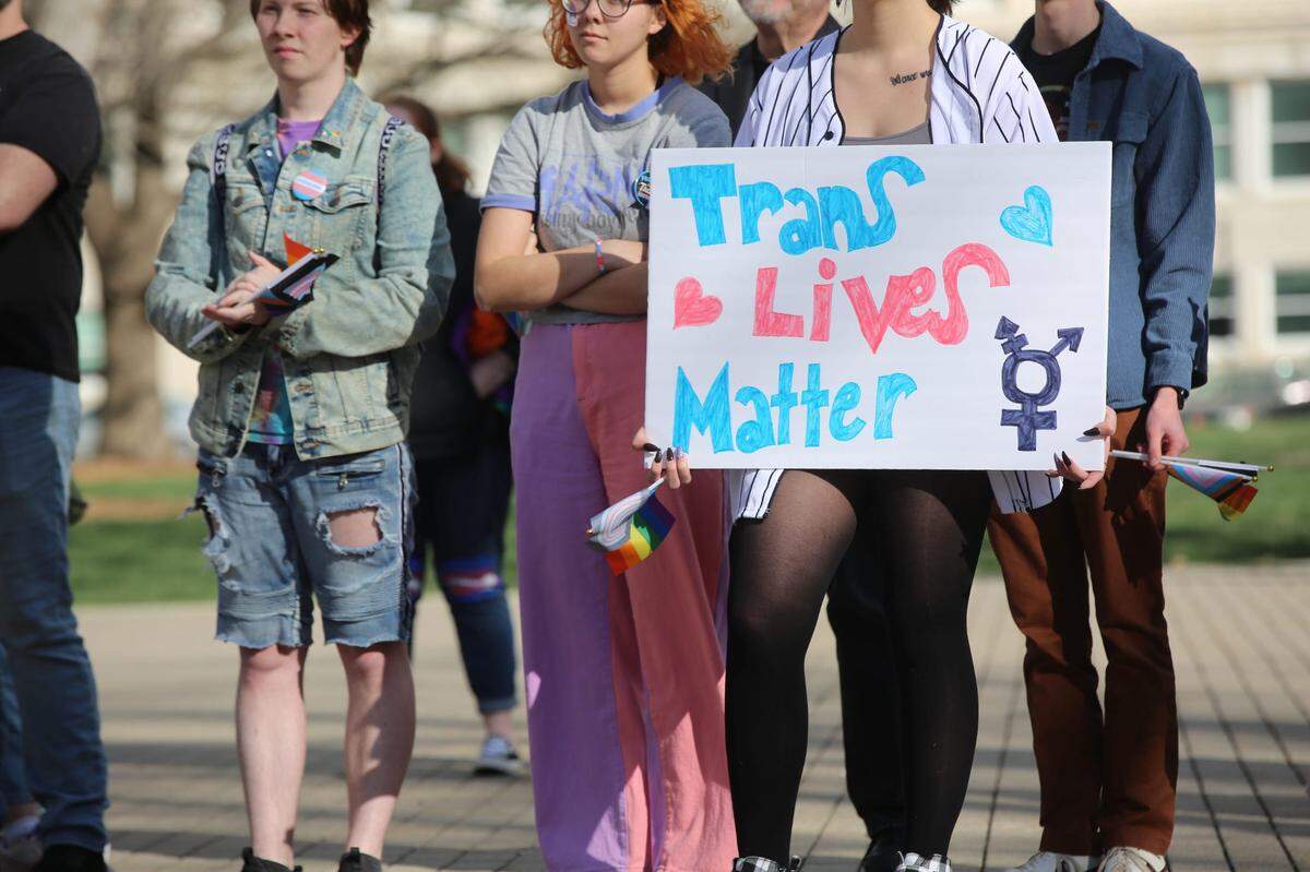 A demonstrator listens to speakers at a rally last week held in support of transgender youth in Kansas. It comes amid a raft of anti-transgender legislation in the Sunflower State. En1 1667