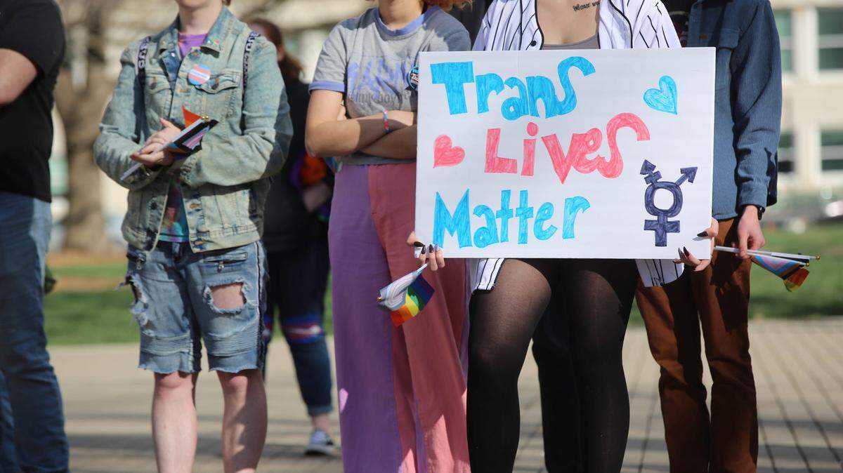 A demonstrator listens to speakers at a rally last week held in support of transgender youth in Kansas. It comes amid a raft of anti-transgender legislation in the Sunflower State. En1 1667