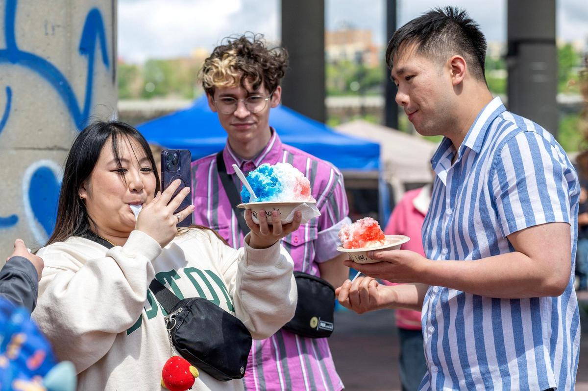 A visitor takes a video of their shaved ice while attending the 4th Annual Taste of AAPI festival.