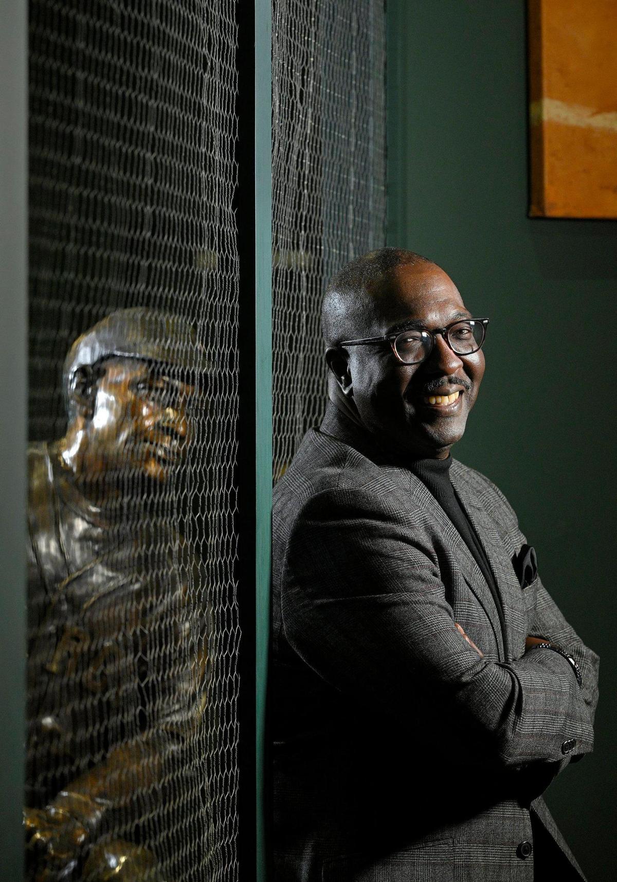 A statue of Buck O’Neil looks on behind Bob Kendrick, president of the Negro Leagues Baseball Museum. O’Neil, the Kansas City Monarchs star player and manager who was passed over for the National Baseball Hall of Fame shortly before his death in 2006, was elected to the hall on Dec. 5, 2021.