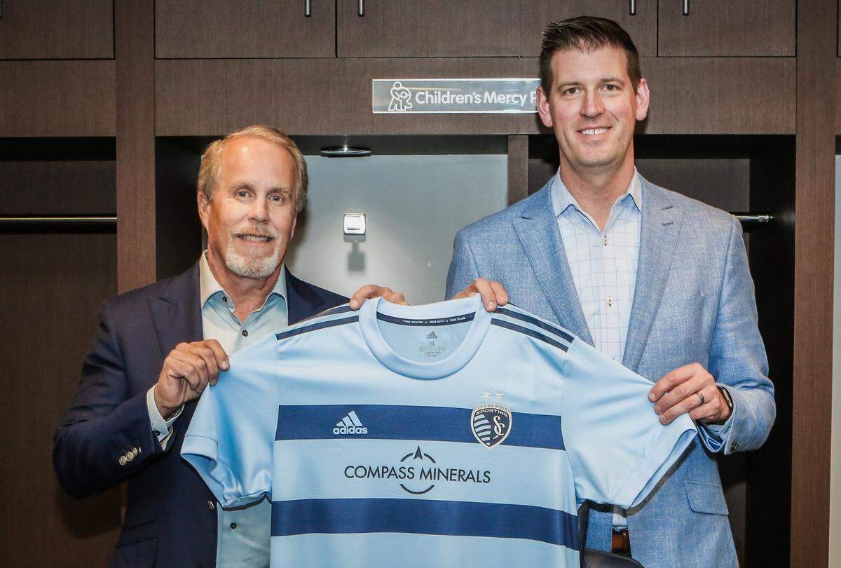 Compass Minerals president and CEO Kevin Crutchfield, left, and Sporting KC president and CEO Jake Reid show off the team’s new jersey sponsorship logo.