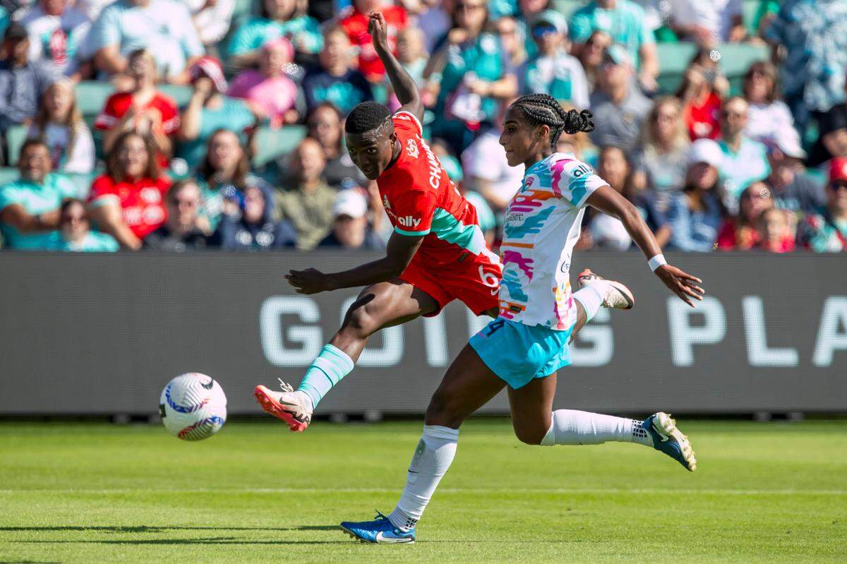Kansas City Current forward Temwa Chawinga leaps around San Diego Wave FC defender Naomi Girma during Saturday’s NWSL match at CPKC Stadium in KC.
