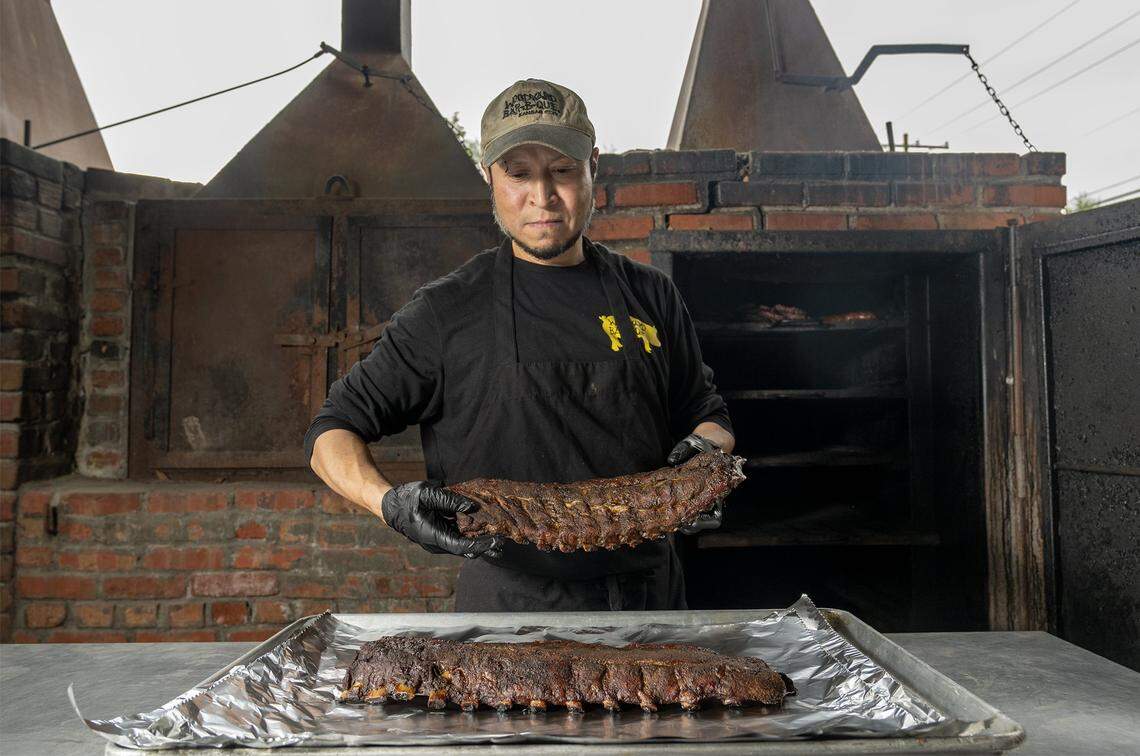 Mario Tacu, a pitmaster, displays two slabs of spare ribs smoked at Woodyard Bar-B-Que, 3001 Merriam Lane, in Kansas City, Kansas, on Tuesday, October 14, 2025.