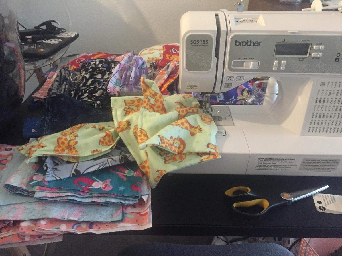 The home of Shana Ayers in Olathe has been overrun by fabric and sewing materials as she stitches up surgical masks for local medical workers to wear should masks run low during the coronavirus emergency.