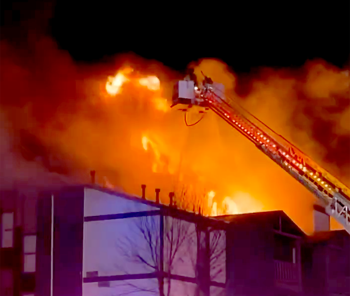 Flames shoot out of the top of a building in the Indy Ridge Apartments complex the 19000 block of East 37th Terrace, north of the Independence Commons shopping center on Wednesday. A resident of a nearby building in the apartment complex shot video of the blaze. The resident who identified herself as Kat, declined to give her last name out of safety concerns.