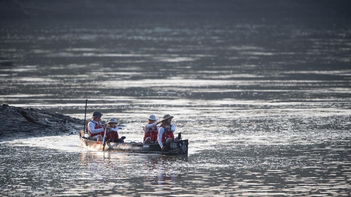 A team competing in the MR340 river race launches from the muddy bank of the Missouri River near Kaw Point.