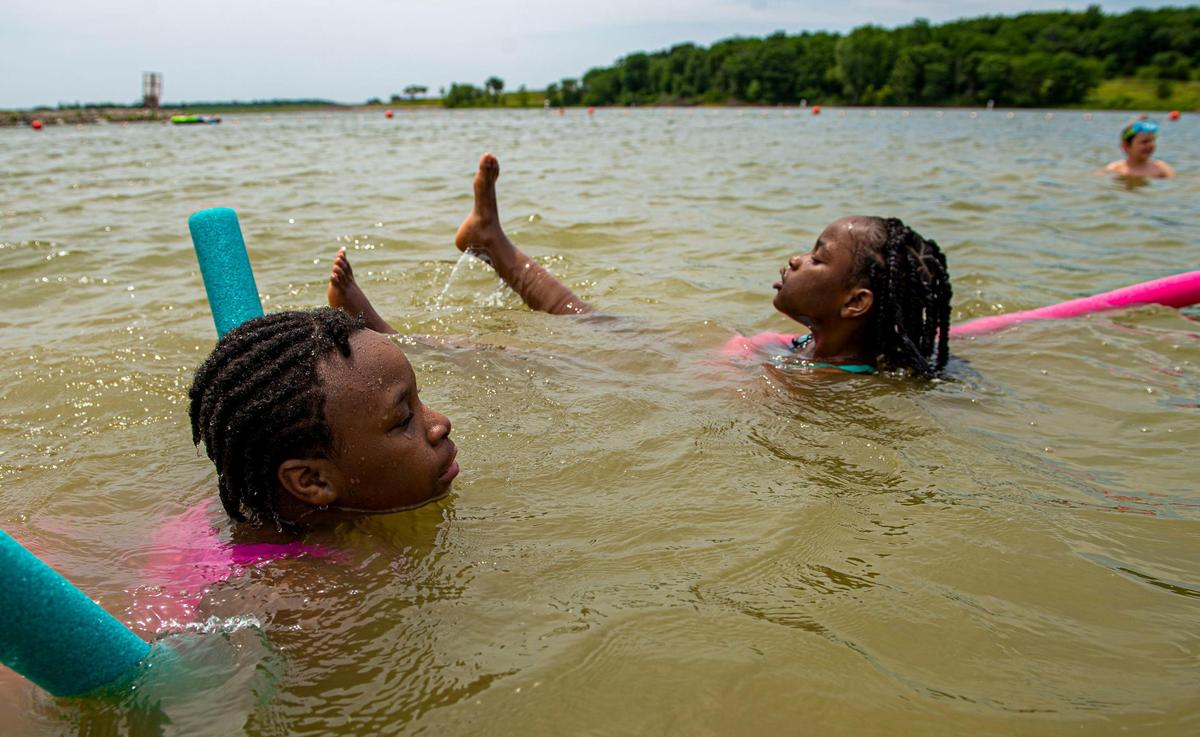Friends Christie Louis, 10, and Maxeana, 8, relax in Smithville Lake at Little Platte Beach.