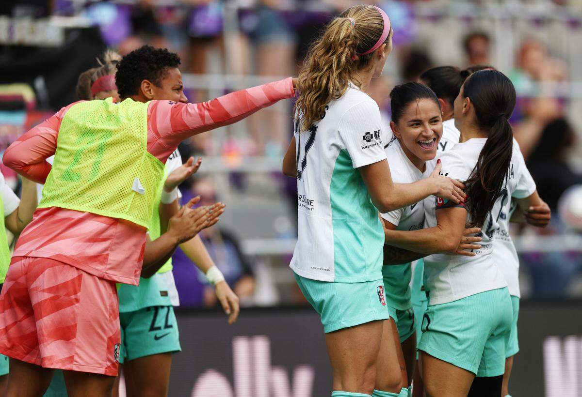 Kansas City Current midfielder Debinha (facing camera) is surrounded by joyous teammates after scoring a first-half goal against the Orlando Pride during an NWSL playoff semifinal soccer match at Inter&Co Stadium in Orlando on Sunday, Nov. 17, 2024.