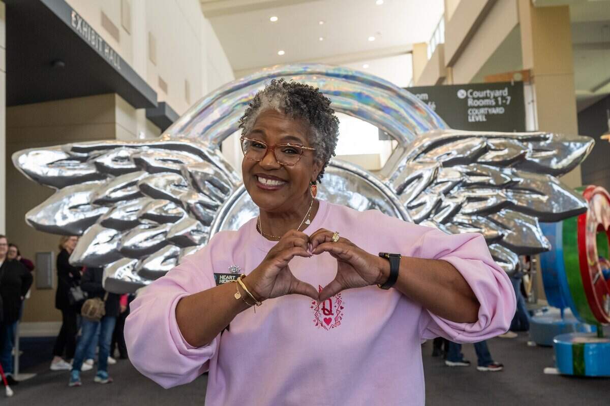 Parade of Hearts Board Chair La'Von Colhour flashes a heart symbol during the first public exhibition of the new hearts titled “150 United,”  on Saturday, April 4, 2026, in Overland Park.