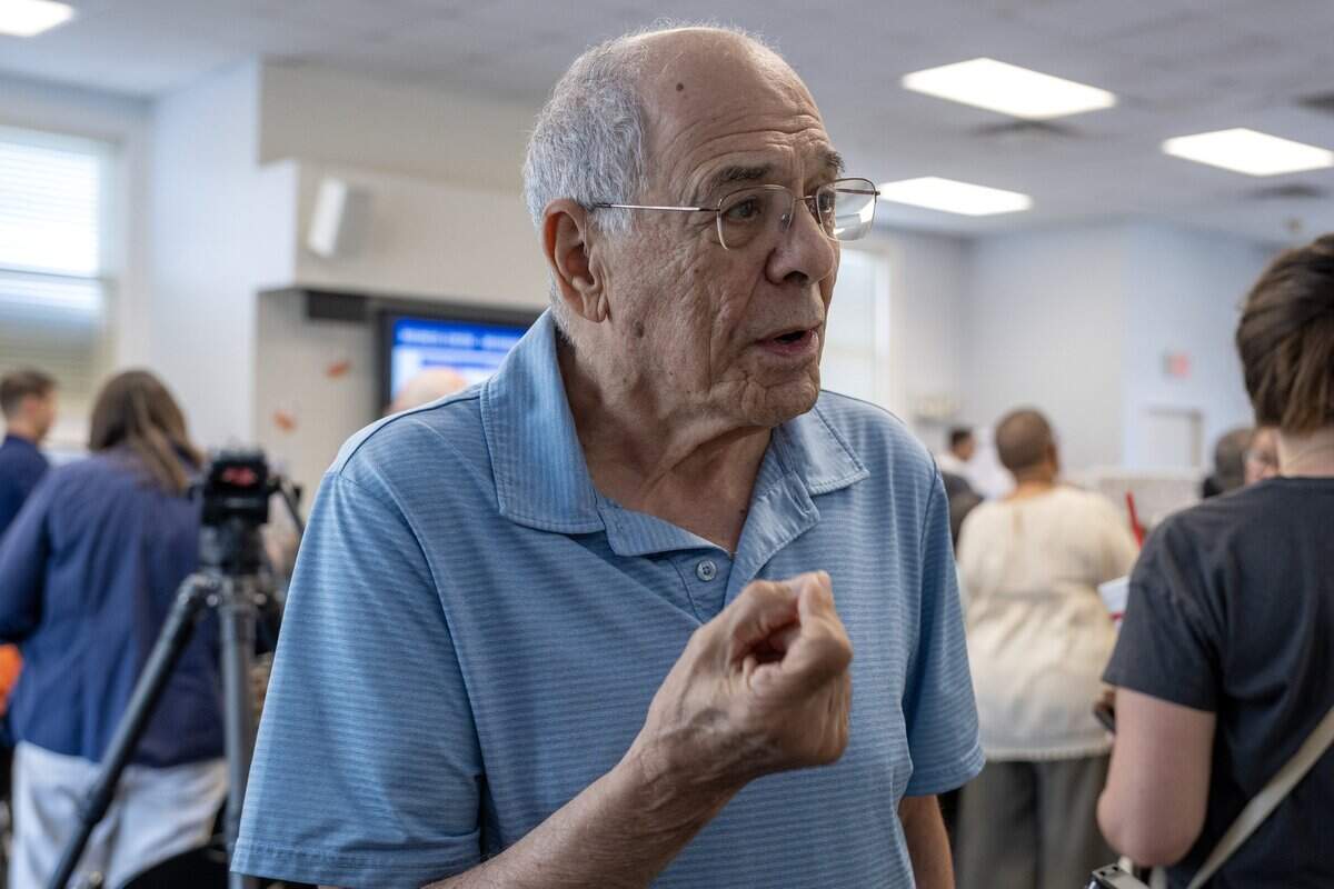 Bruce Apple, Midtown resident, speaks to a reporter about the proposed Costco Linwood Business Center zoning changes during a public meeting at the Westport Library Tuesday, July 7, 2026, in Kansas City.