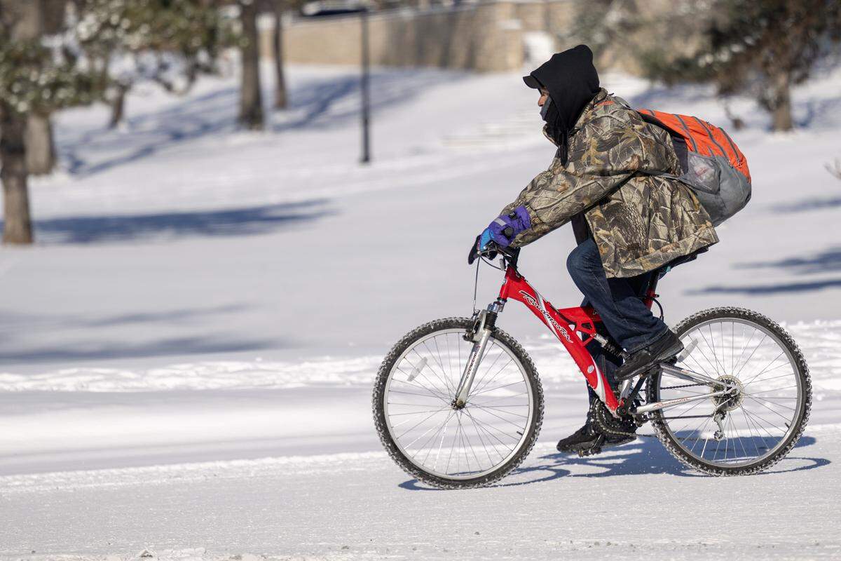The snow and bitterly cold temperatures were no match for a cyclist who pedaled near the Country Club Plaza on Sunday, Jan. 25, 2026, navigating the frozen streets in the wake of the weekend storm in Kansas City.