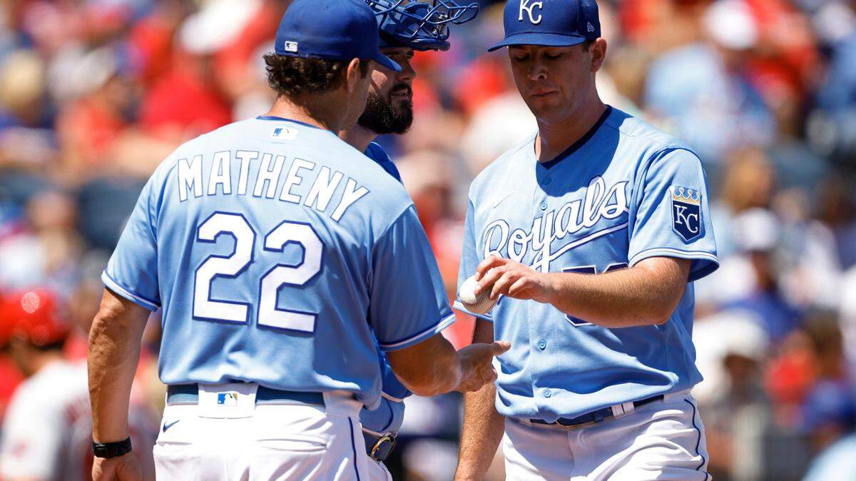 Kansas City Royals manager Mike Matheny (22) takes the ball from pitcher Kris Bubic, center, as catcher Cam Gallagher, second left, looks on during the second inning of a baseball game at Kauffman Stadium in Kansas City, Mo., Sunday, Aug. 15, 2021. Bubic gave up seven runs before being taken out of the game. (AP Photo/Colin E. Braley)