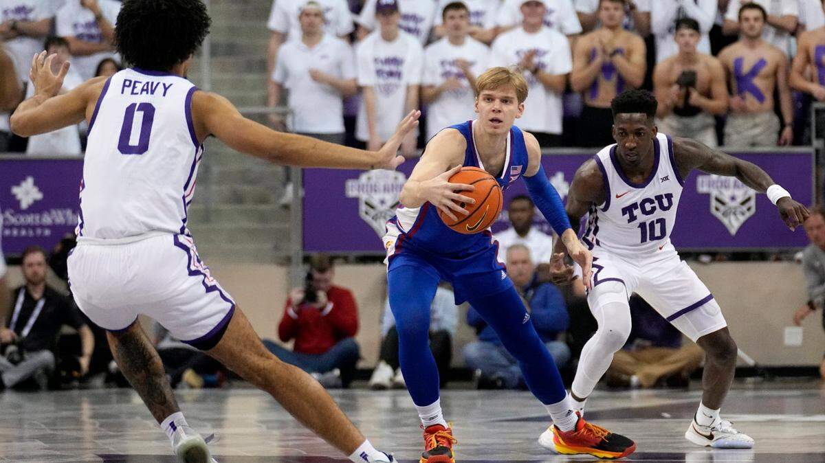 Kansas guard Gradey Dick recovers a loose ball between TCU’s Micah Peavy (0) and Damion Baugh (10) in the first half of an NCAA college basketball game, Monday, Feb. 20, 2023, in Fort Worth, Texas. (AP Photo/Tony Gutierrez)