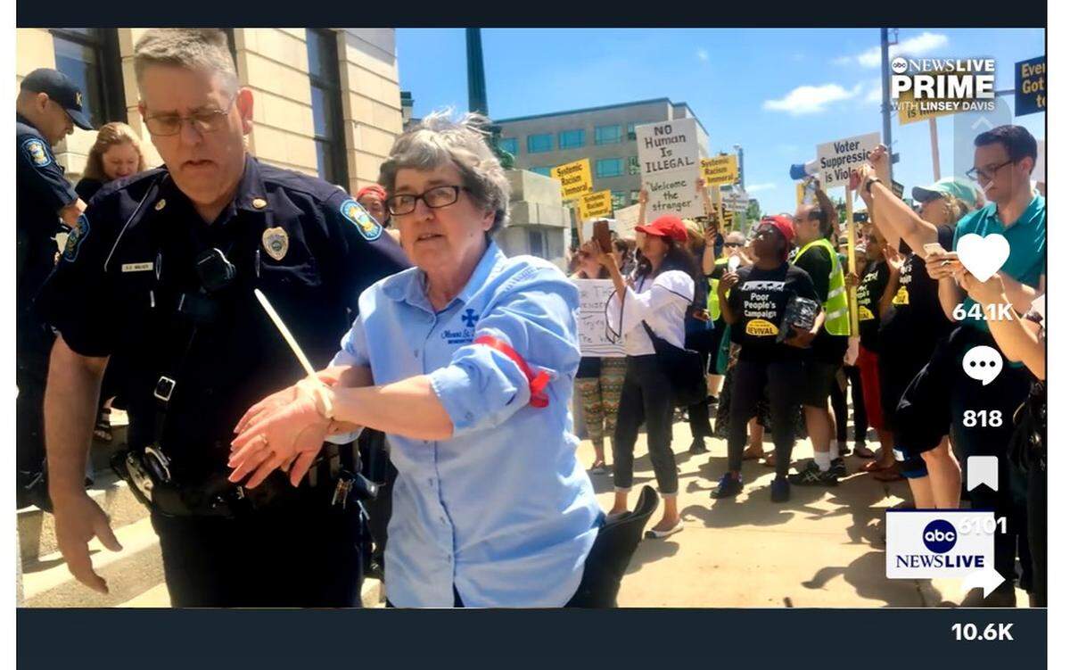 Sister Barbara McCracken being led to jail in Topeka after occupying the office of then-Secretary of State Kris Kobach over immigration and voter identification policies.