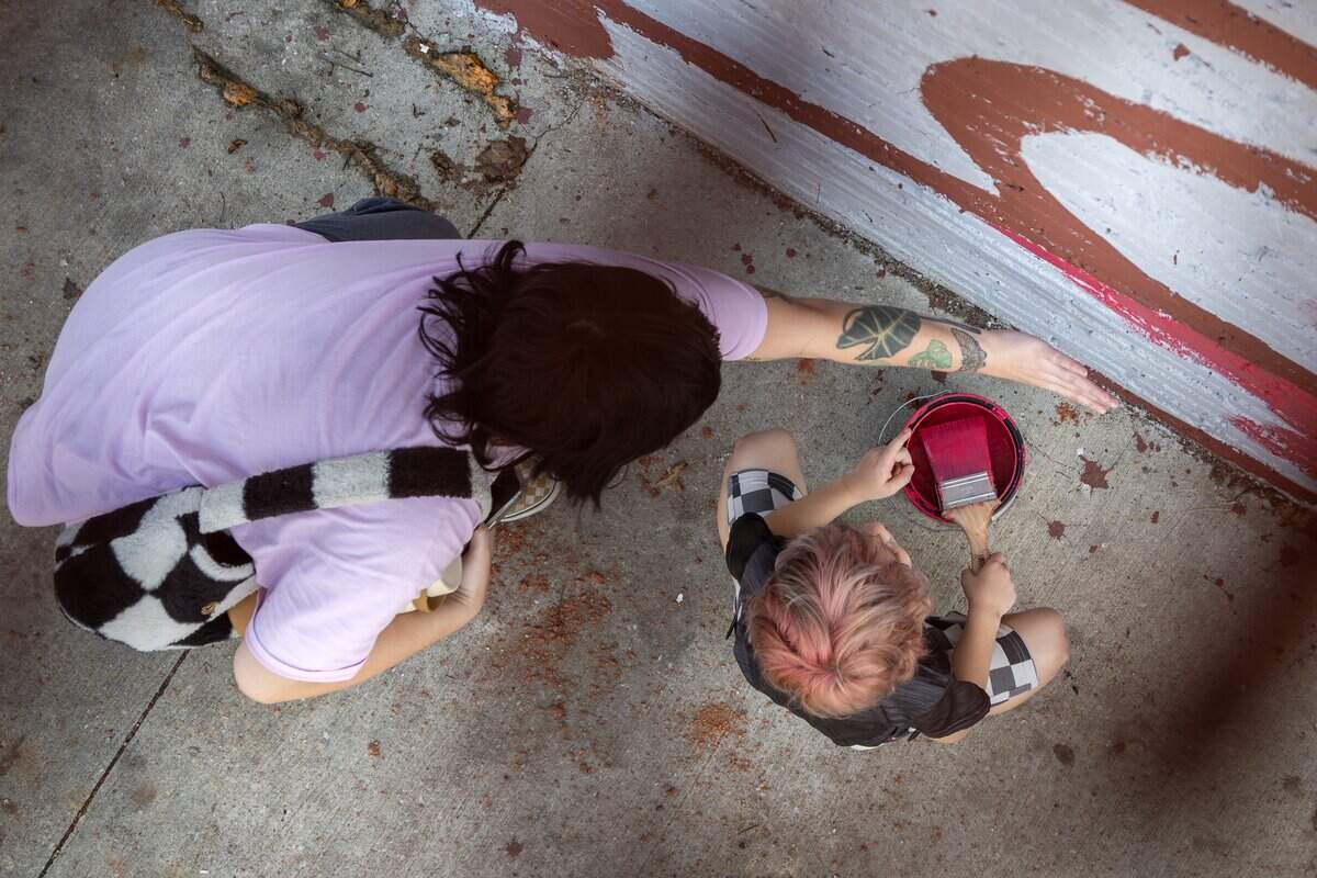 Truly Chrisman and her 5-year-old son, Wake Cooper, help paint part of a Chappell Roan mural along Broadway Boulevard on Wednesday, Sept. 24, 2025, in Kansas City. Wake, a fan of Chappell Roan, asked artist Jared Horman if he could join in.