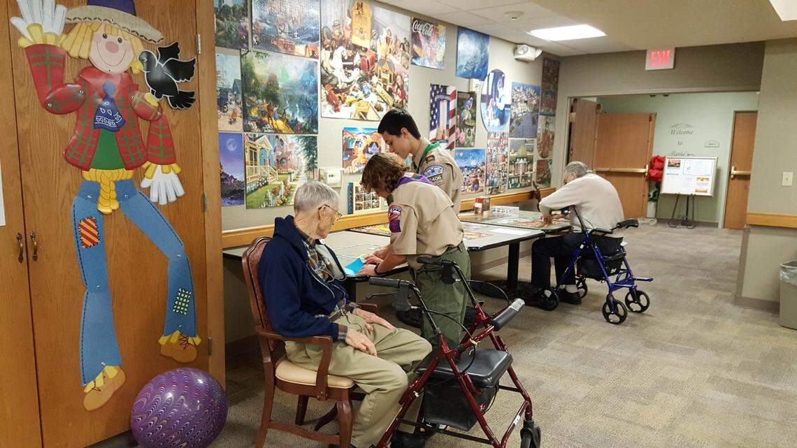 Boy Scouts from Troop 91, led by Evan Clark, teach seniors at Rose Estates assisted living to do origami in 2018. Evan received a Kindness Action Scholarship from SevenDays this year for the project.