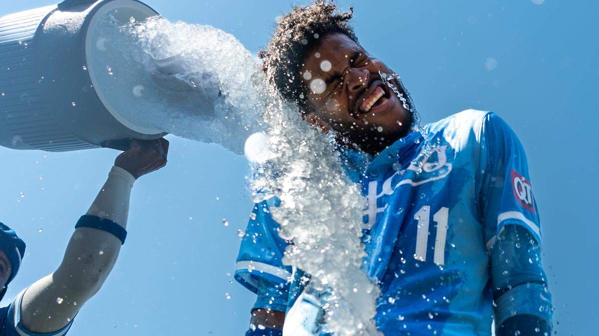 Kansas City Royals third baseman Maikel Garcia (11) is doused with water by right fielder Nelson Velazquez (17) after defeating the New York Yankees at Kauffman Stadium on June 13, 2024.
