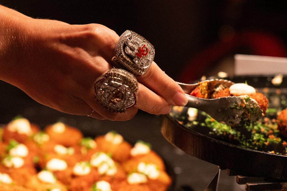 A guest at the 13th Annual Chiefs Style Lounge wore a couple of the Chiefs recent Super Bowl rings while getting some of the food offerings at Tuesday’s show.