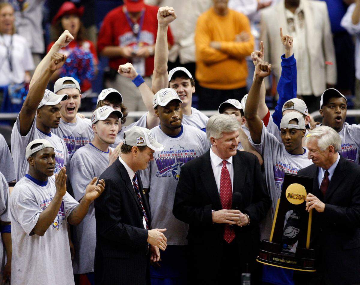 Members of the Kansas Jayhawks celebrate as head coach Bill Self is presented with the national championship trophy after defeating the Memphis Tigers in the finals of the 2008 NCAA Men’s Final Four Championship at the Alamodome.