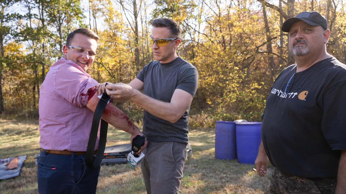 Missouri Democratic candidate for U.S. Senate Lucas Kunce applies first aid to KSHB 41 reporter Ryan Gamboa after Gamboa was struck by ricochet from a bullet fragment shot from a gun handled by Kunce during a sport shooting campaign event Tuesday, Oct. 22, 2024 in Holt, Missouri.