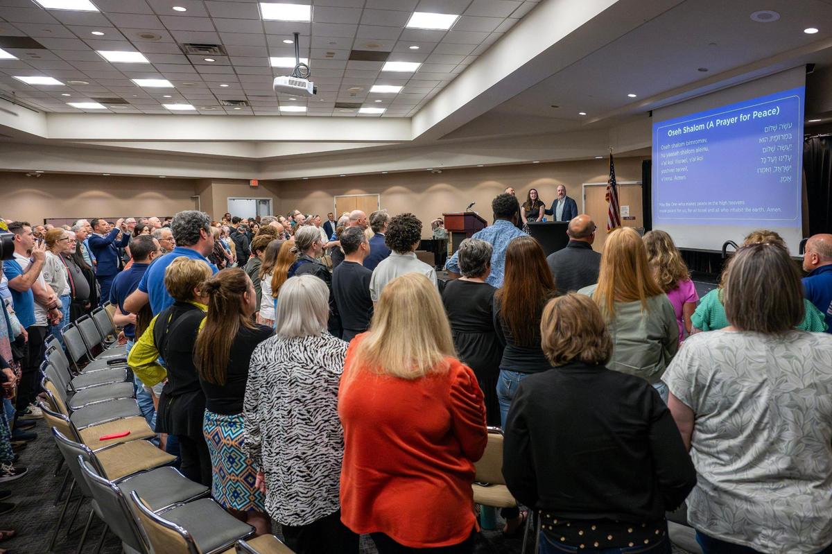 Rabbi Neil Schuster leads mourners in singing “Oseh Shalom” during a vigil for Sarah Milgrim and Yaron Lischinsky at the Social Hall of the Jewish Community Center on Thursday, May 22, 2025, in Overland Park. Milgrim and Lischinsky were killed outside the Capital Jewish Museum in Washington, D.C., on Wednesday, May 21.