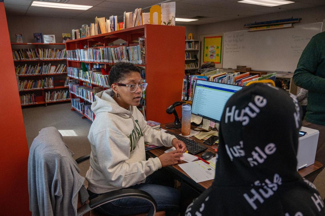 Kenya Harris, librarian, helps a student check out a book in the mobile library at Eugene Ware Elementary School on Tuesday, April 16, 2024, in Kansas City, Kansas.