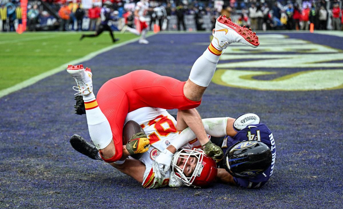 Kansas City Chiefs tight end Travis Kelce (87) comes down with a touchdown catch in front of Baltimore Ravens safety Kyle Hamilton (14) in the first quarter Sunday, Jan. 28, 2024, during the AFC Championship Game in Baltimore.