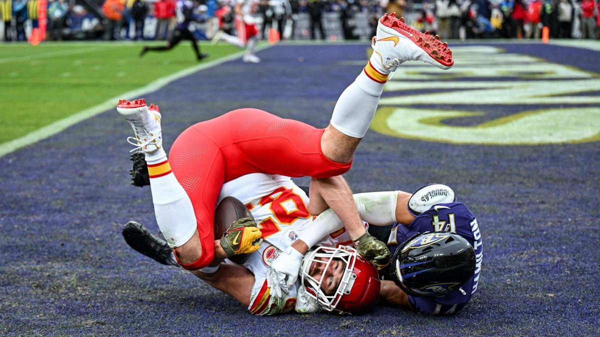 Kansas City Chiefs tight end Travis Kelce (87) comes down with a touchdown catch in front of Baltimore Ravens safety Kyle Hamilton (14) in the first quarter Sunday, Jan. 28, 2024, during the AFC Championship Game in Baltimore.
