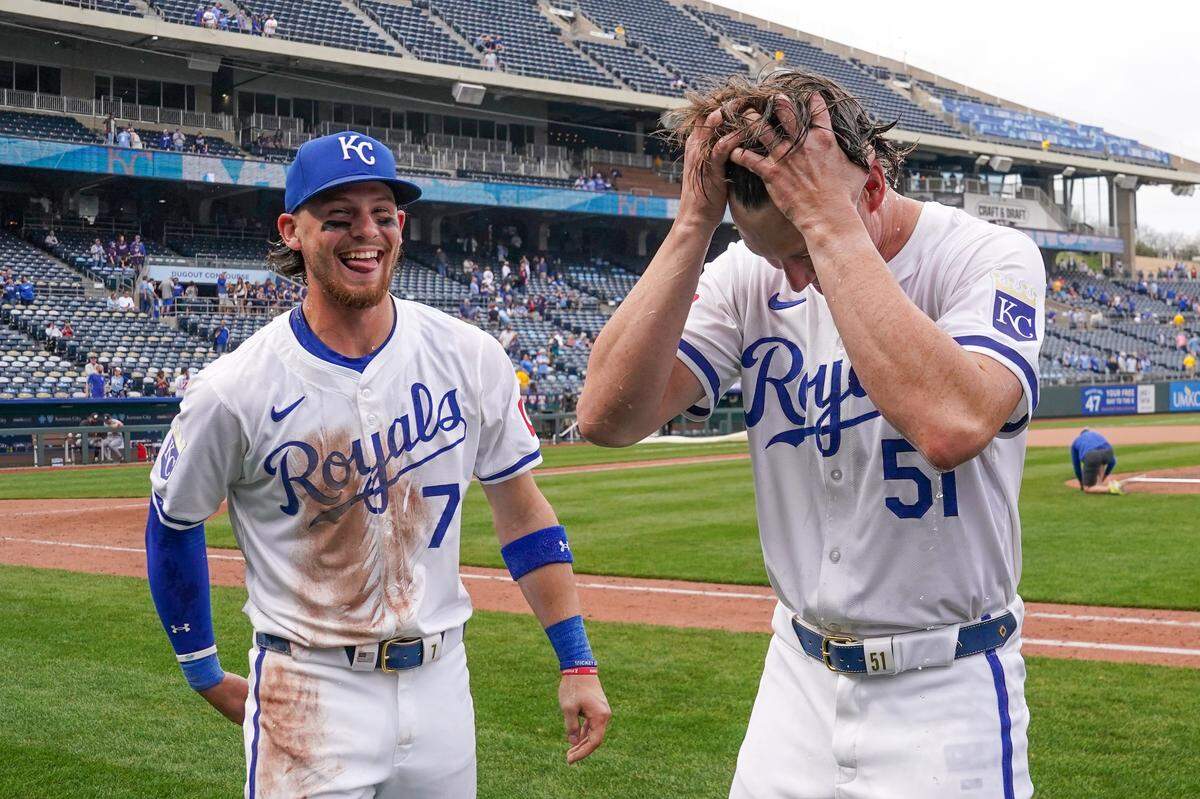 Kansas City Royals shortstop Bobby Witt Jr., left, and starting pitcher Brady Singer laugh at being doused after the team’s win against the Minnesota Twins at Kauffman Stadium on Sunday.