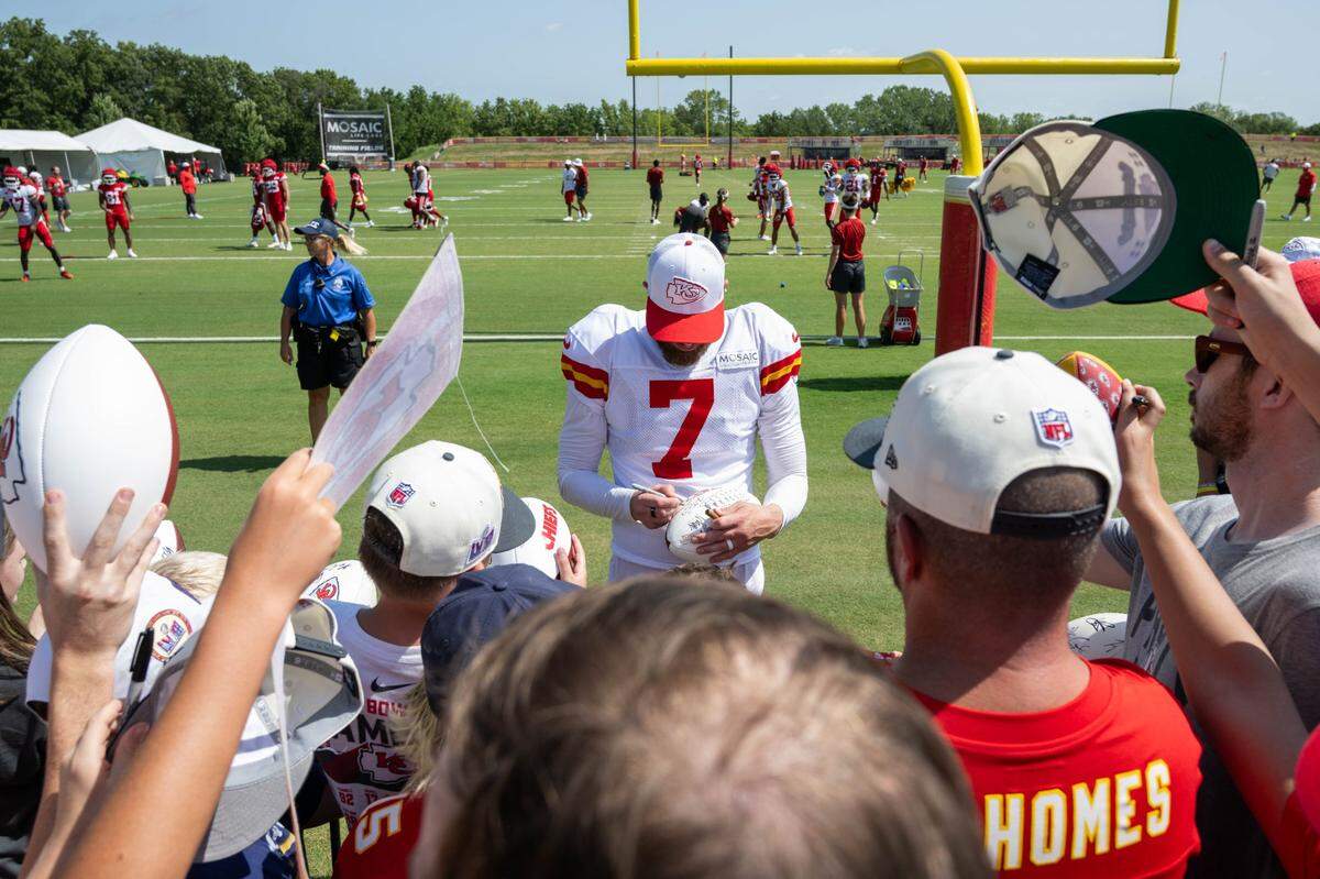 Kansas City Chiefs kicker Harrison Butker signs autographs after a training camp practice.