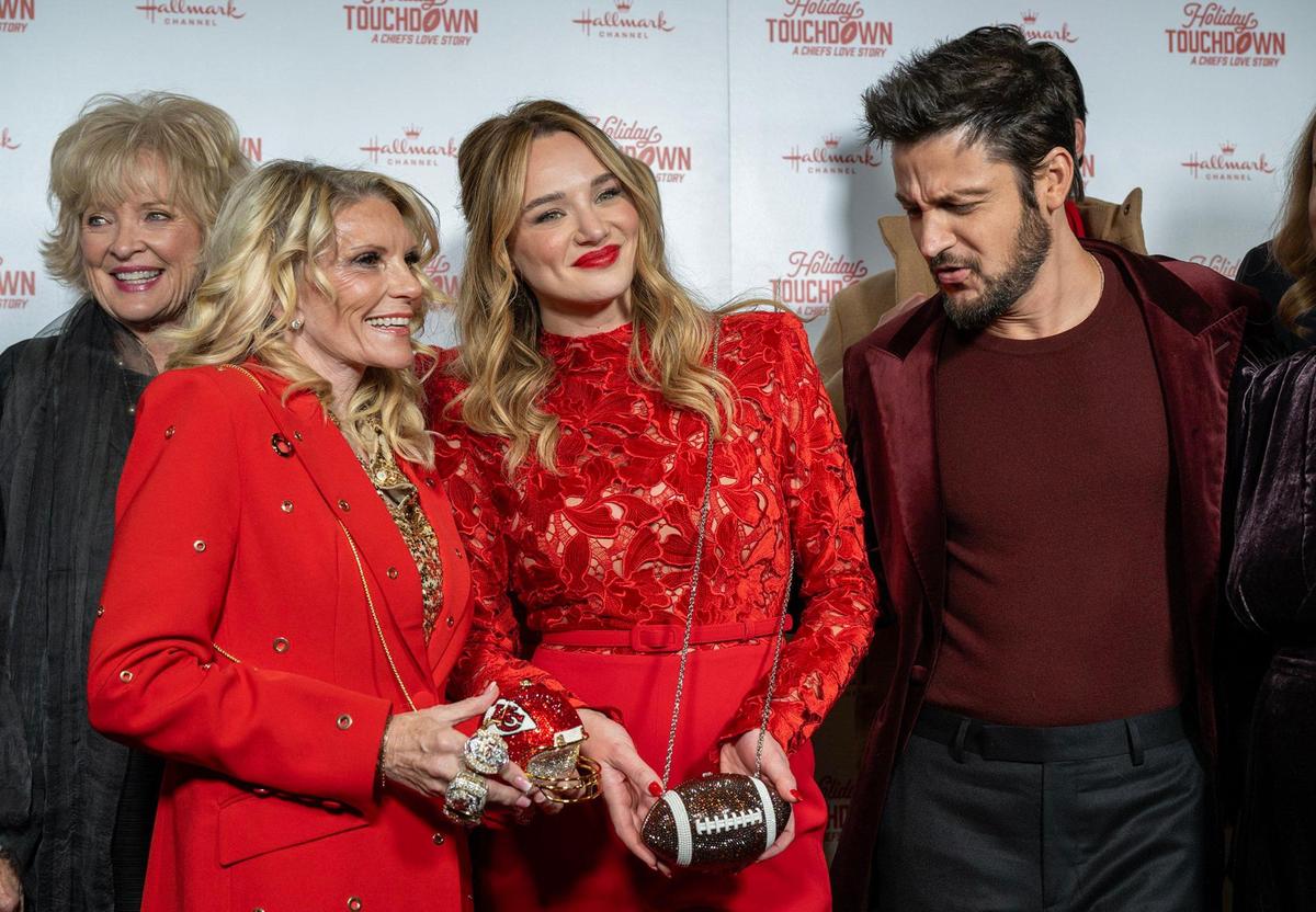Tammy Reid and Hunter King display their football-themed purses as Tyler Hynes looks on at the premiere screening of Hallmark’s “Holiday Touchdown: A Chief’s Love Story” on Saturday, Nov. 30, 2024, at the Sheraton Kansas City Hotel at Crown Center.