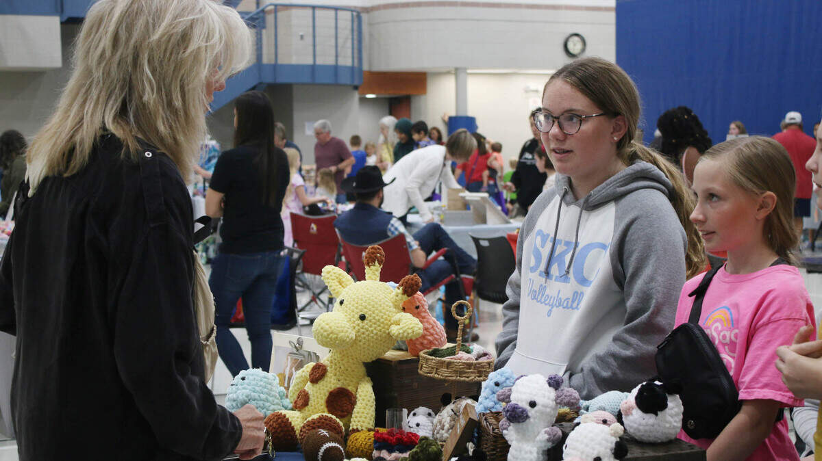 Laura Harsch, of Prairie Village, talks with Khloe Pyron, 12, and Ali Smith, 12, about their merchandise at the KidsFest Business Fair in Shawnee Sept. 9.
