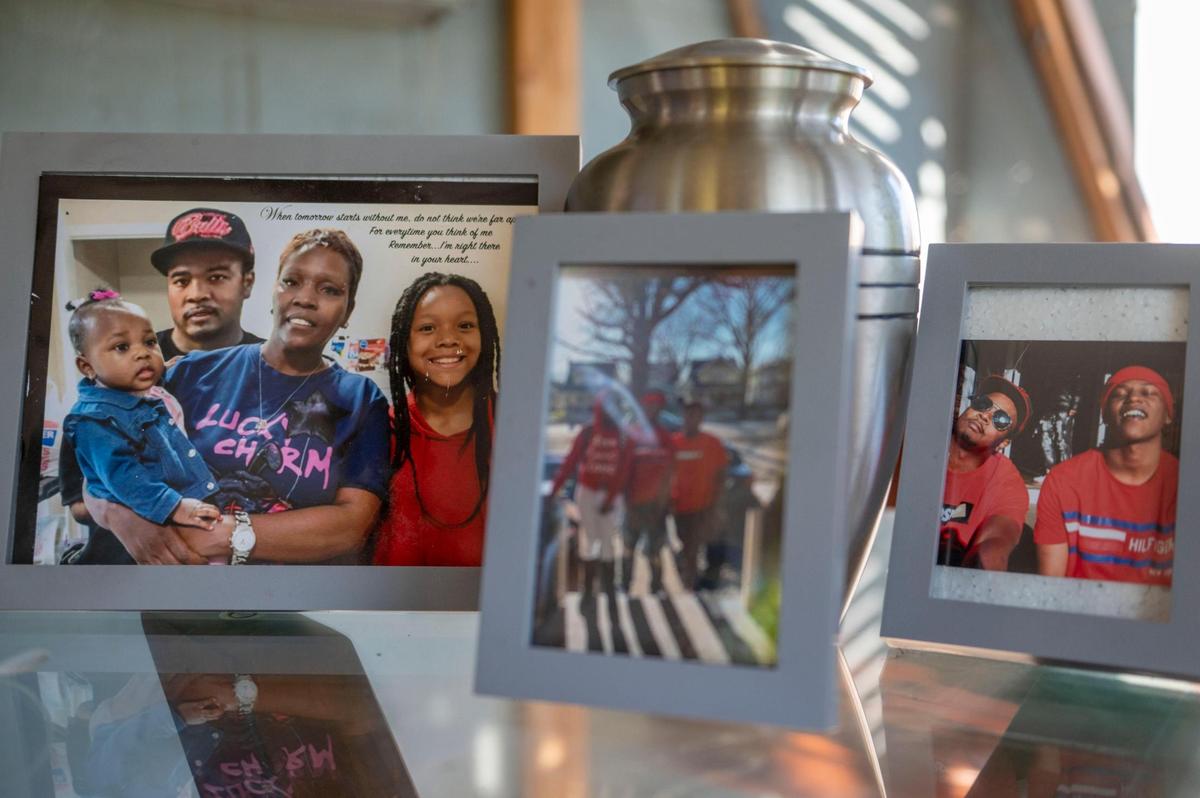 A collage of framed photos and a cremation urn is displayed on a table at Cynnita Oliver’s home during a family gathering on Aug. 9 in the Oak Park neighborhood. Oliver’s son, Derrick Davis, was killed in the 3700 block of Benton Boulevard two years ago.