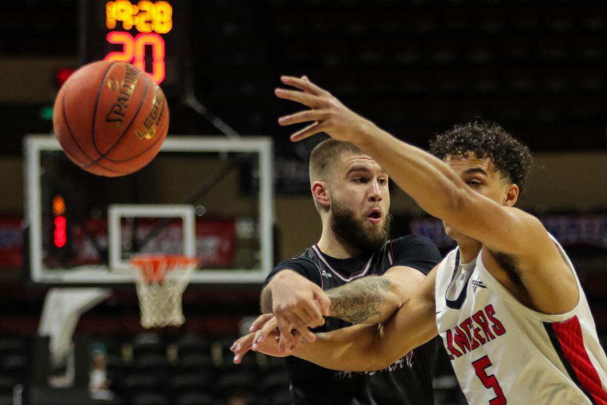 Blue Springs South High School grad Devin Tomlinson passes the ball to a Freed-Hardeman teammate during Monday’s first NAIA semifinal game. Freed-Hardeman beat Grace College 86-81 to advance to Tuesday’s championship game at Municipal Auditorium.