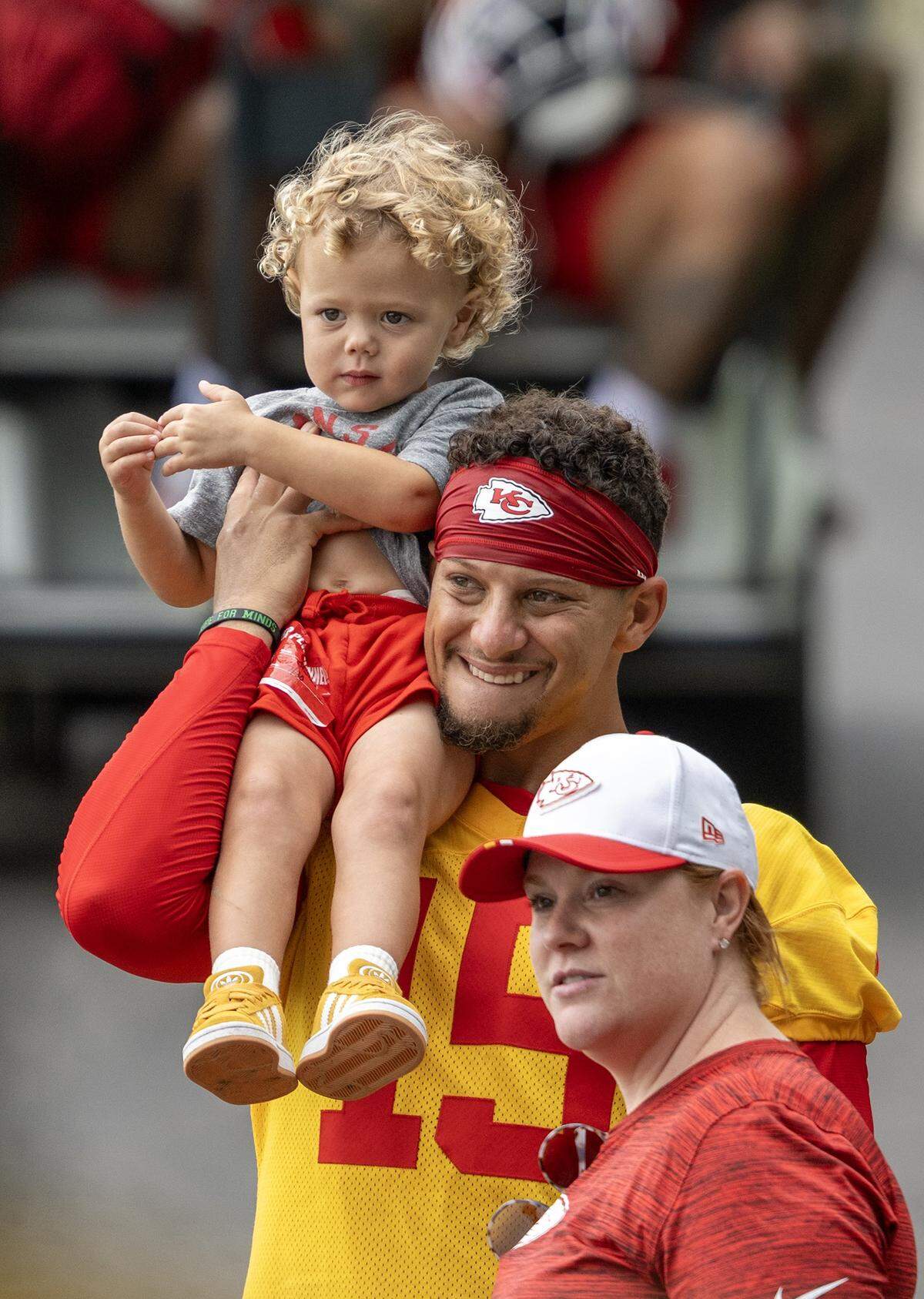 Kansas City Chiefs quarterback Patrick Mahomes (15) carries his son, Patrick "Bronze" Lavon Mahomes III at training camp at Missouri Western State University on Wednesday, July 30, 2025, in St. Joseph, Missouri.