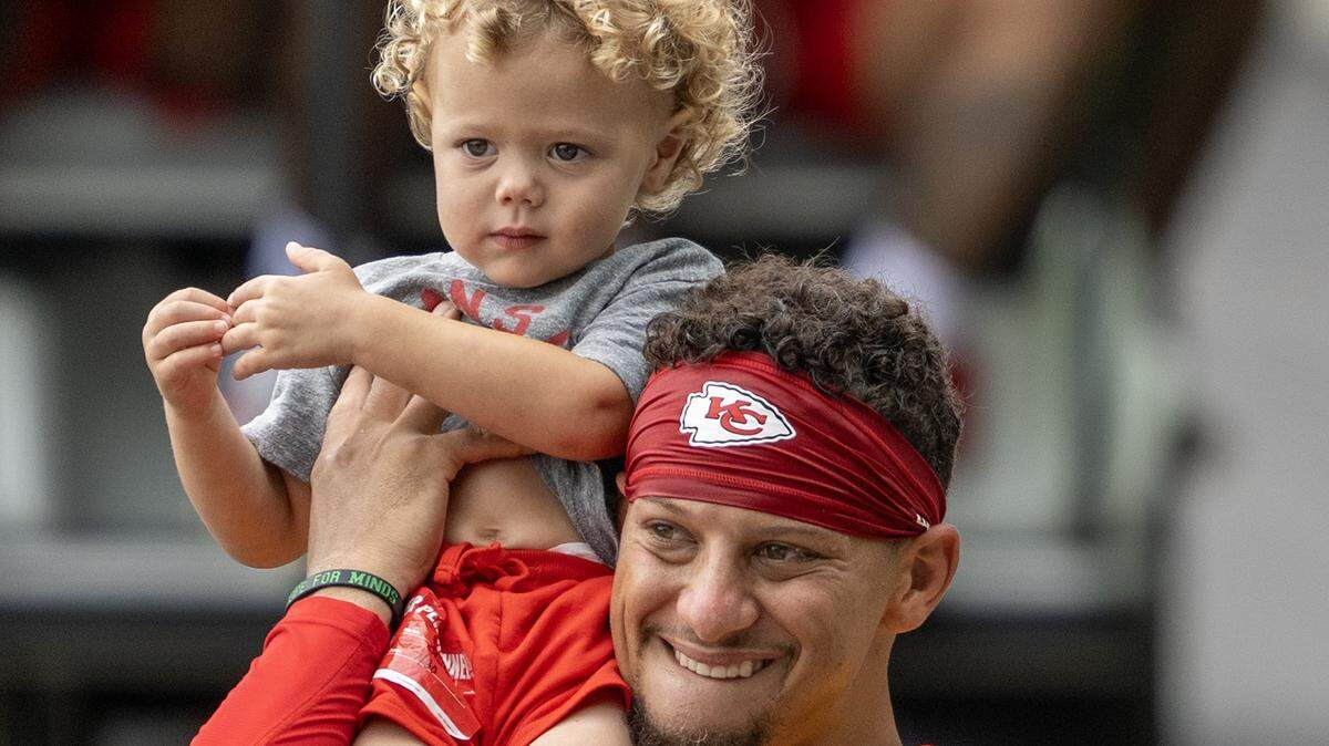 Kansas City Chiefs quarterback Patrick Mahomes (15) carries his son, Patrick "Bronze" Lavon Mahomes III at training camp at Missouri Western State University on Wednesday, July 30, 2025, in St. Joseph, Missouri.