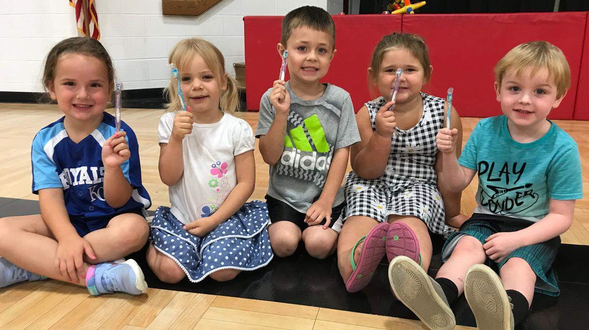 Students at East Lynne Elementary show off the toothbrushes they received at the free dental screening conducted by Cass Community Heath Foundation.