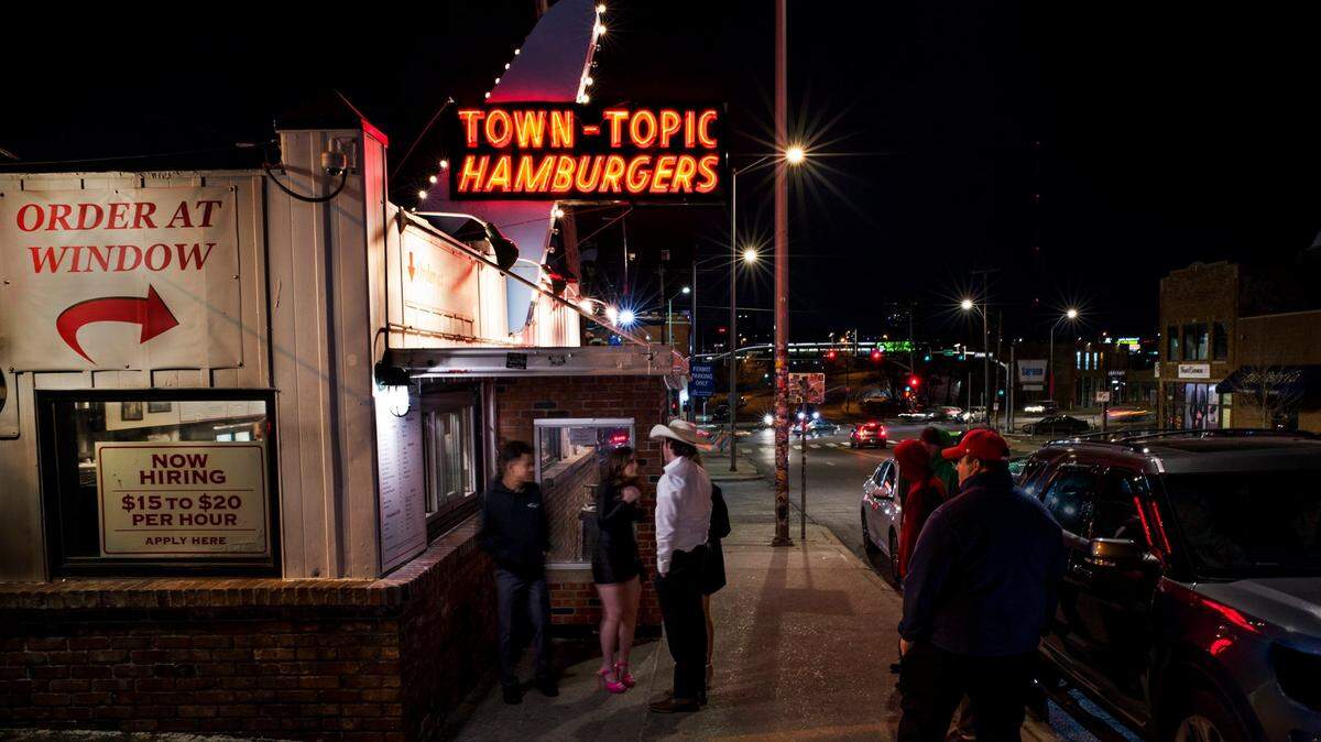 On a chilly February night in 2023, customers line up outside of Town-Topic Hamburgers on Broadway in the Crossroads District of Kansas City. The iconic diner opened in 1937 and is open around the clock.