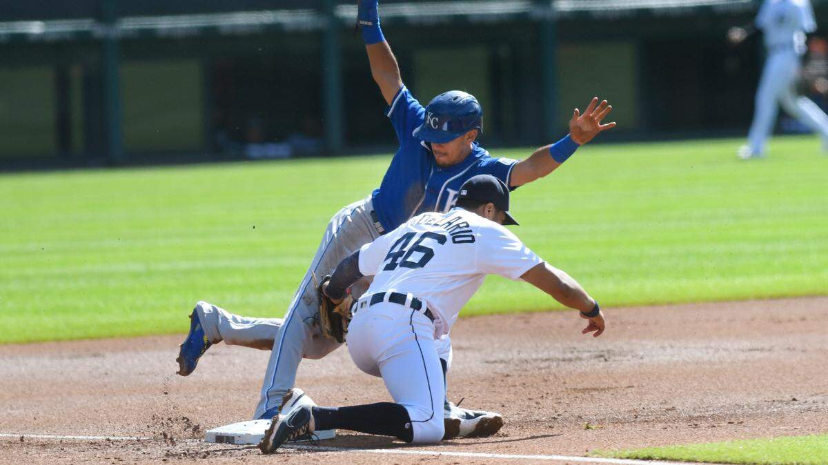 Kansas City Royals’ Nicky Lopez, top, steals third base as Detroit Tigers third baseman Jeimer Candelario tags too late in the first inning of a baseball game, Sunday, Sept. 26, 2021, in Detroit. (AP Photo/Jose Juarez)