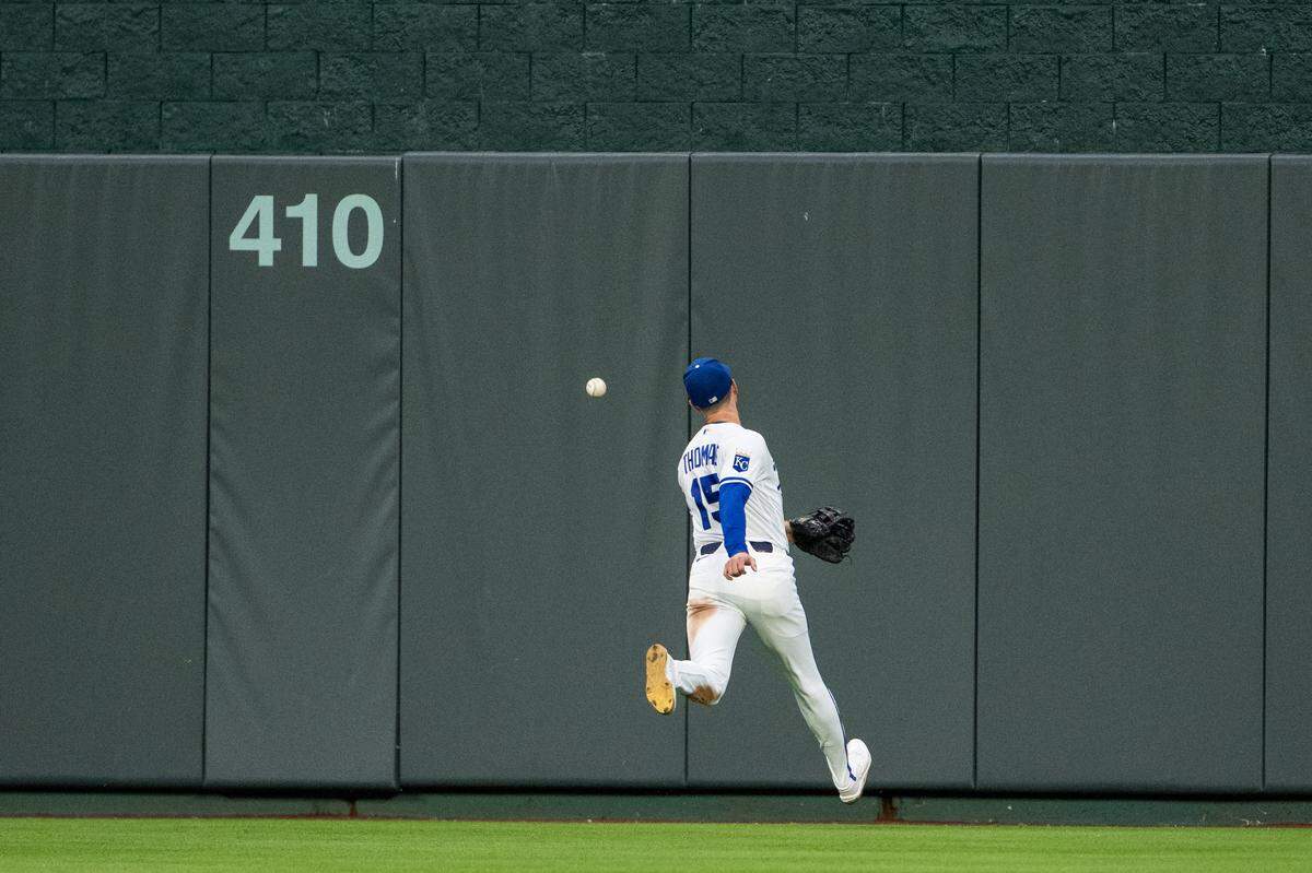 Kansas City Royals center fielder Lane Thomas chases after a ball hit over his head during a game against the Boston Red Sox on Tuesday, May 19, 2026, at Kauffman Stadium.