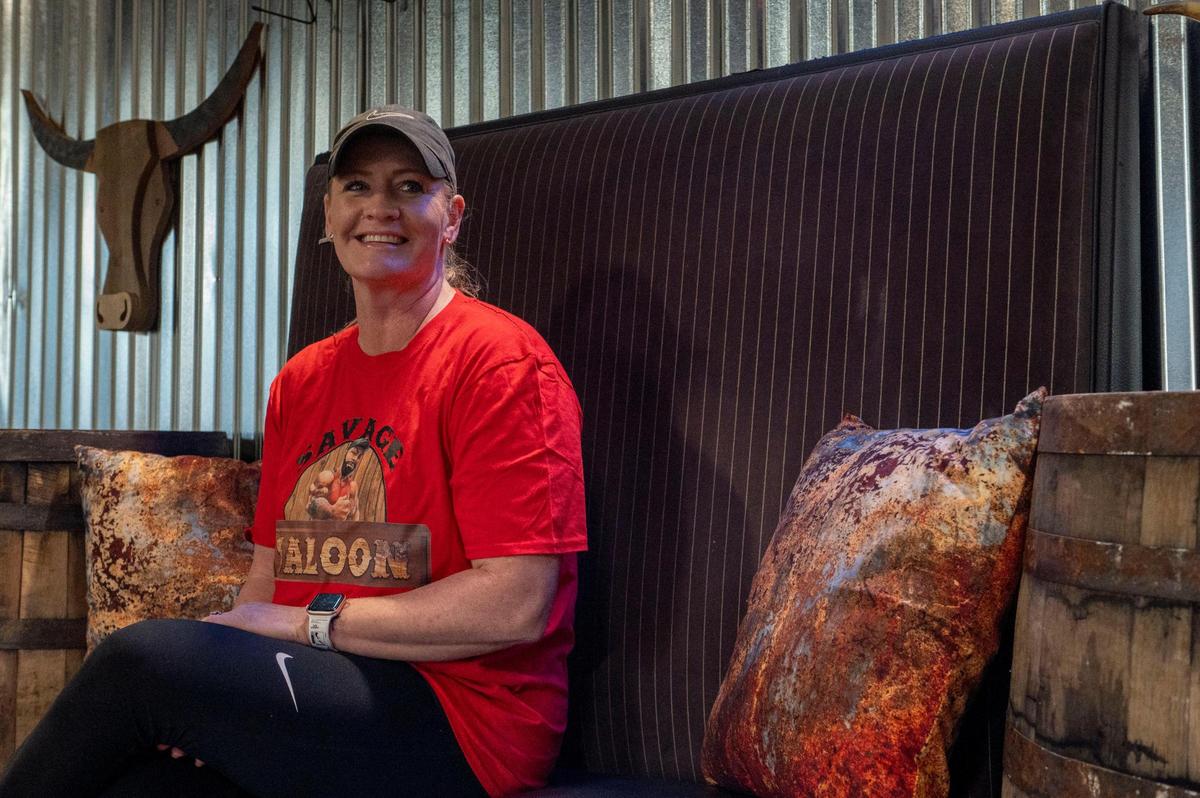 Tracy McDaniel, co-owner of Savage Saloon, sits in the bar’s lounging area.
